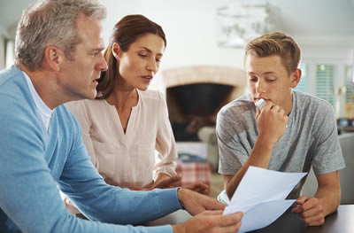 Family of 3 looking at and discussing paperwork.