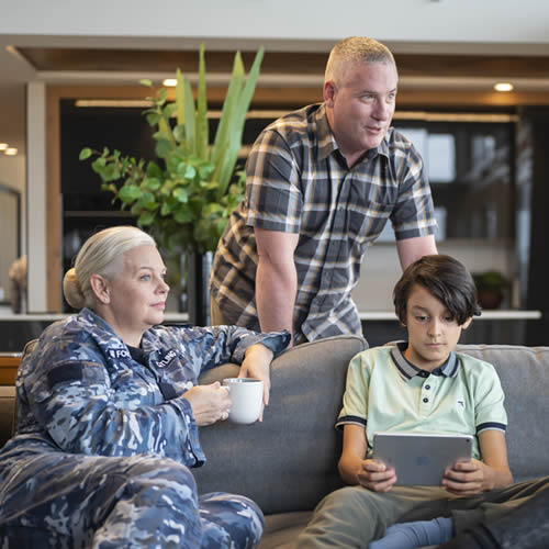 Family of 3 relaxing in their home, mother in air force uniform.