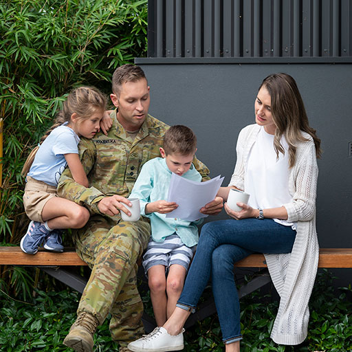 Family with father in army uniform gather to read paperwork.