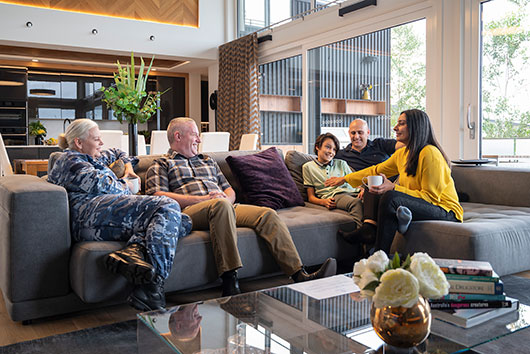 Extended family seated on couch enjoying their living space.