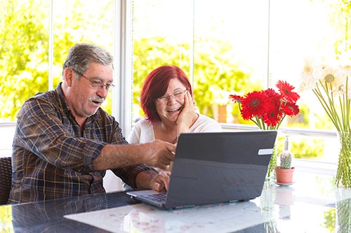 A couple sitting in front of a laptop.