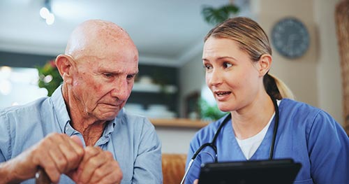 An old veteran is listening to a medical nurse