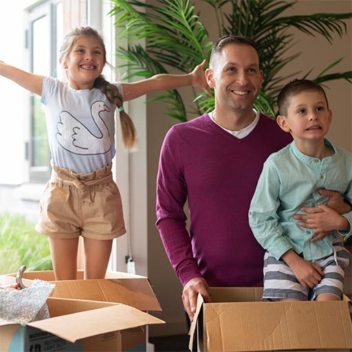 A father with two children unpacking boxes.